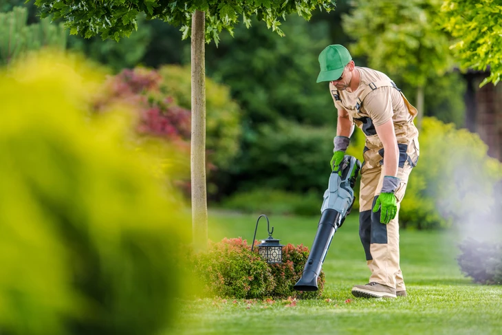 Paysage professionnel dans ses années 40 effectuant l'entretien des jardins arrière-cour
